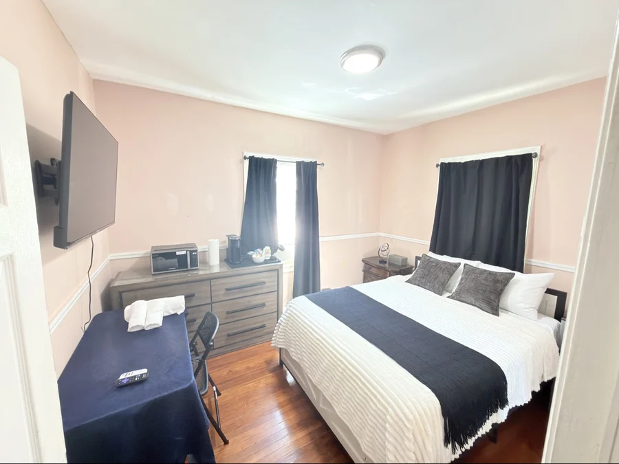 Airbnb bedroom with made bed and folded towels