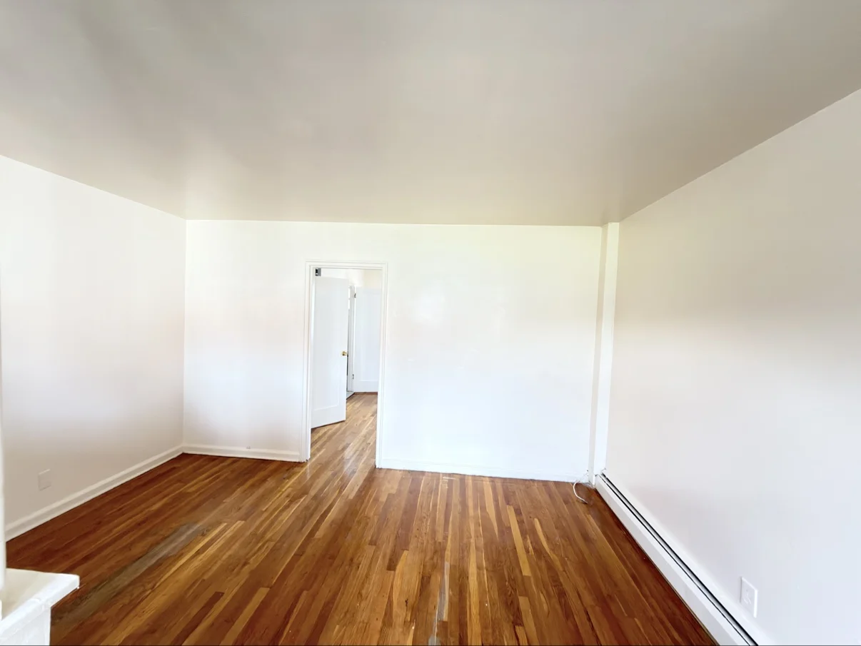 Deluxe Mixed Cleaning post-construction cleaning — freshly cleaned empty room with polished wood floors